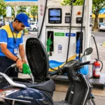 Fuel station attendant refueling a scooter at a petrol pump in India, representing the proposed transition to E25 petrol and its impact on vehicle owners.