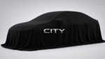 2026 Honda City facelift teaser image covered under black cloth with illuminated CITY logo front view